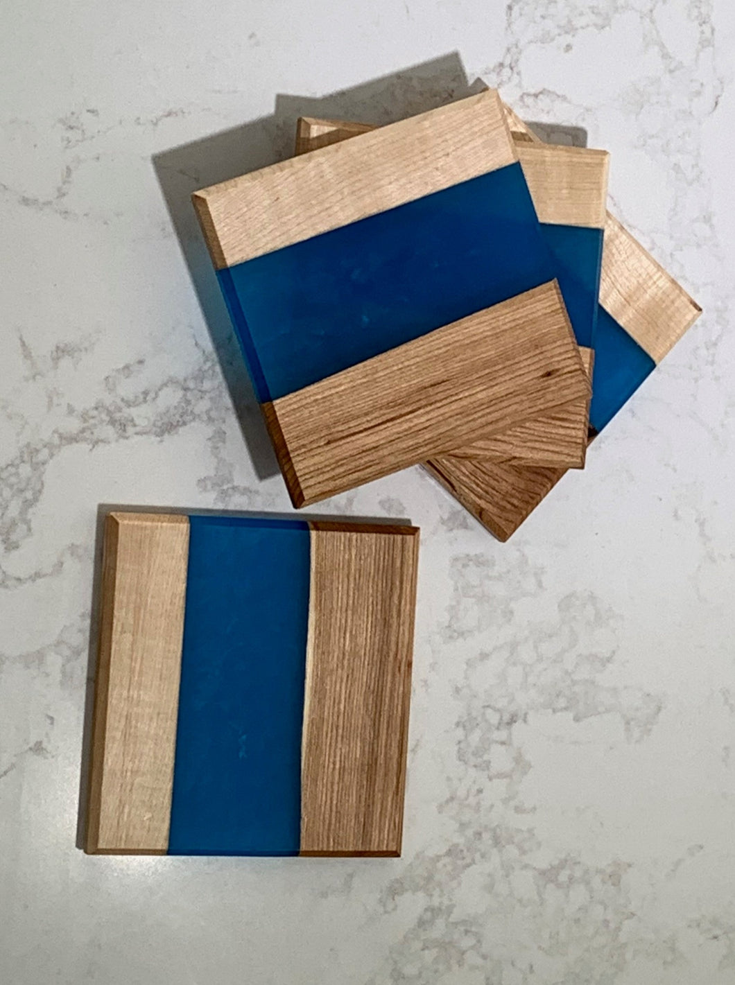 Set of 4 coasters, light maple, dark maple, and blue